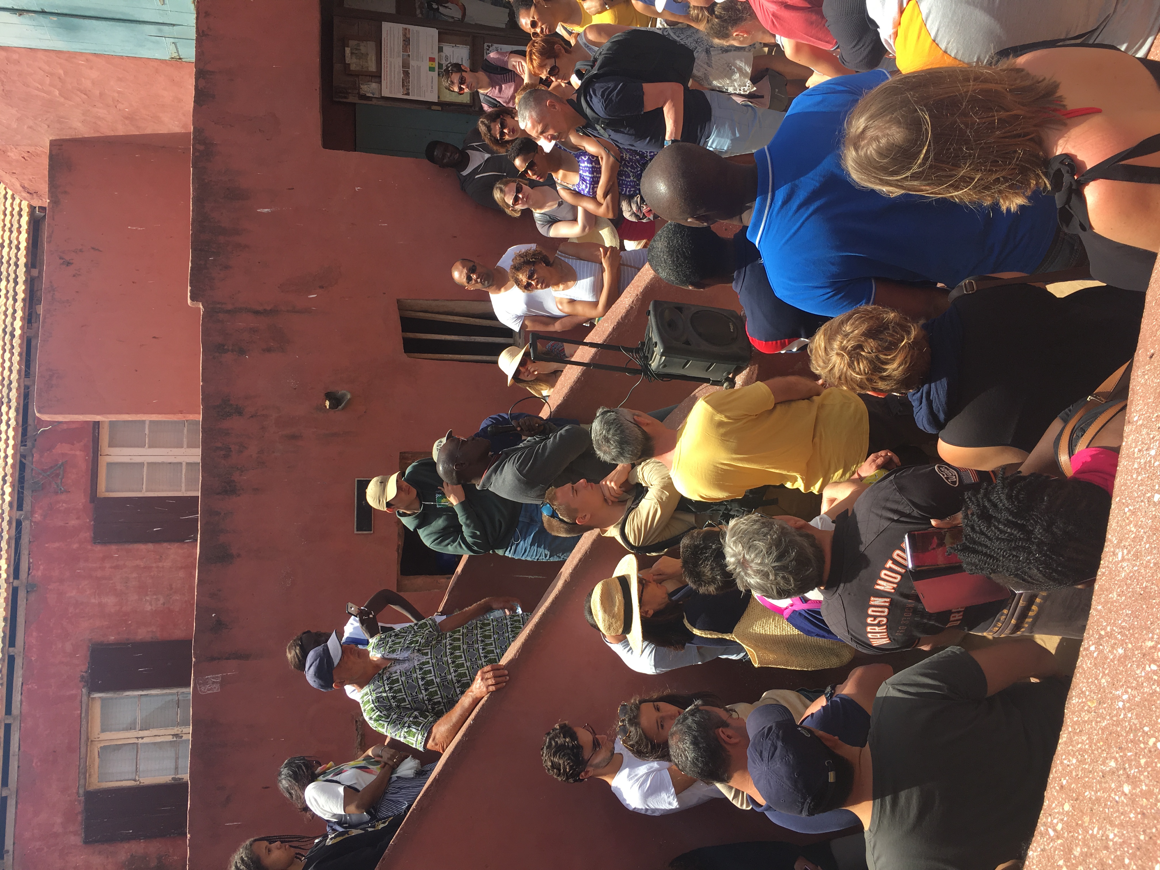 back view of woman wearing a backpack and beanie waiting to cross the road on a busy street at night in New York City, USA